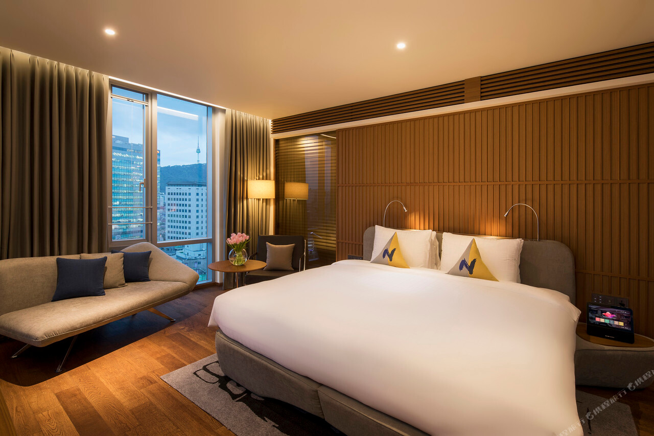 Novotel Ambassador Seoul Dongdaemun 客房床鋪與窗邊休憩區